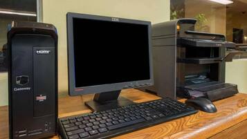 Una computadora de escritorio Gateway con un monitor y una impresora sobre un escritorio de madera.