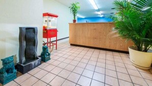 Un espace d’accueil avec un bureau en bois, un kiosque rouge et des plantes en pot.