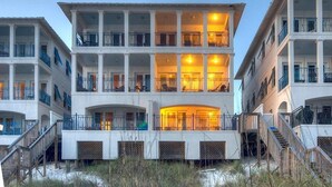 Ett hotell med flera våningar, balkonger, en central innergård och utsikt över stranden.