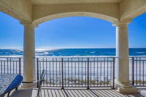 A covered outdoor area with a view of the ocean, featuring a railing and a table. - Vista Bella del Mar 5 Bedroom Holiday Home by Five Star Properties (Santa Rosa Beach)
