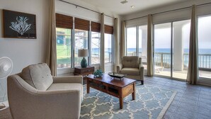 Ein geräumiges Wohnzimmer mit einem großen Fenster und Meerblick.