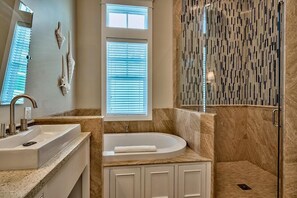 Une salle de bain moderne avec une baignoire sur pieds, un lavabo et un espace douche.