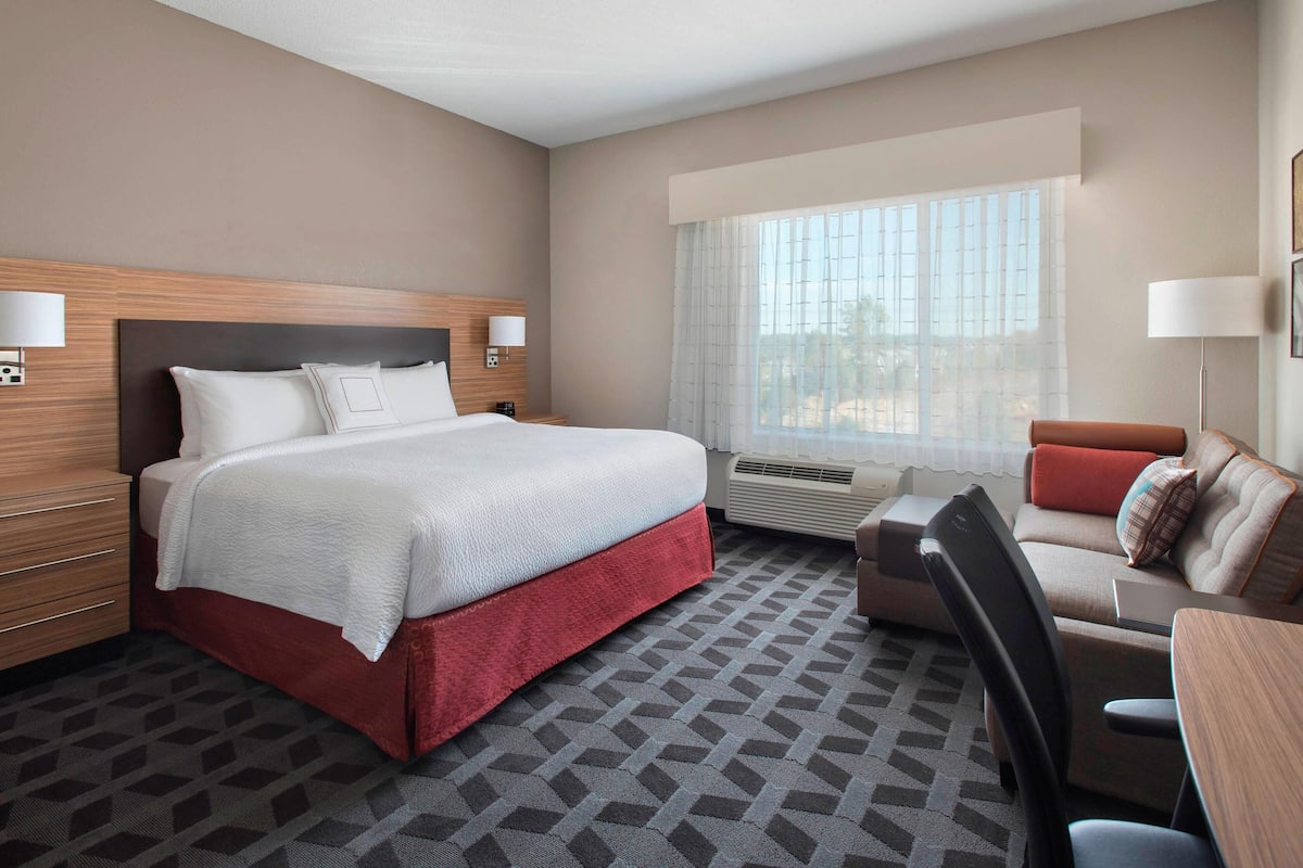Une chambre d’hôtel avec un grand lit, un bureau, une chaise et un canapé.