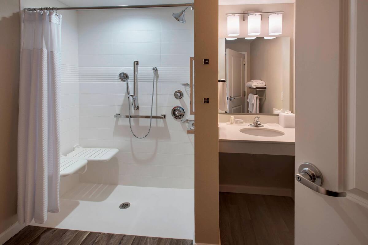 Une salle de bain moderne avec une douche à l’italienne, des toilettes et un lavabo.