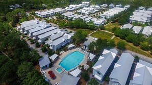 An aerial view of a residential area with multiple houses, a swimming pool, and a small park. - Summer Dreams 4 Bedroom Holiday Home by Five Star Properties (Santa Rosa Beach)