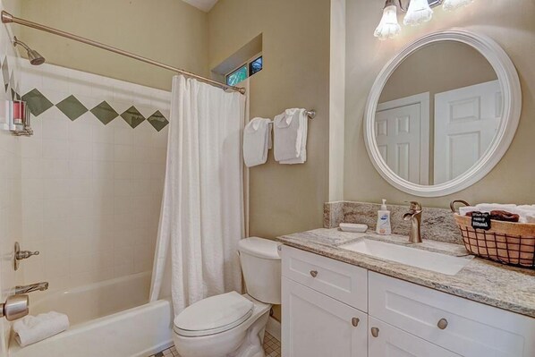 A bathroom with a bathtub, toilet, sink, and a mirror. - GOING COASTAL 3 Bedroom Holiday Home by Five Star Properties (Panama City Beach)