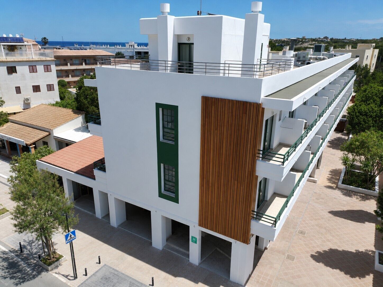A modern building with a flat roof, large windows, and a wooden panel accent.