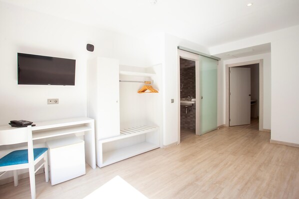A modern, minimalistic room with a desk, chair, and built-in shelving.
