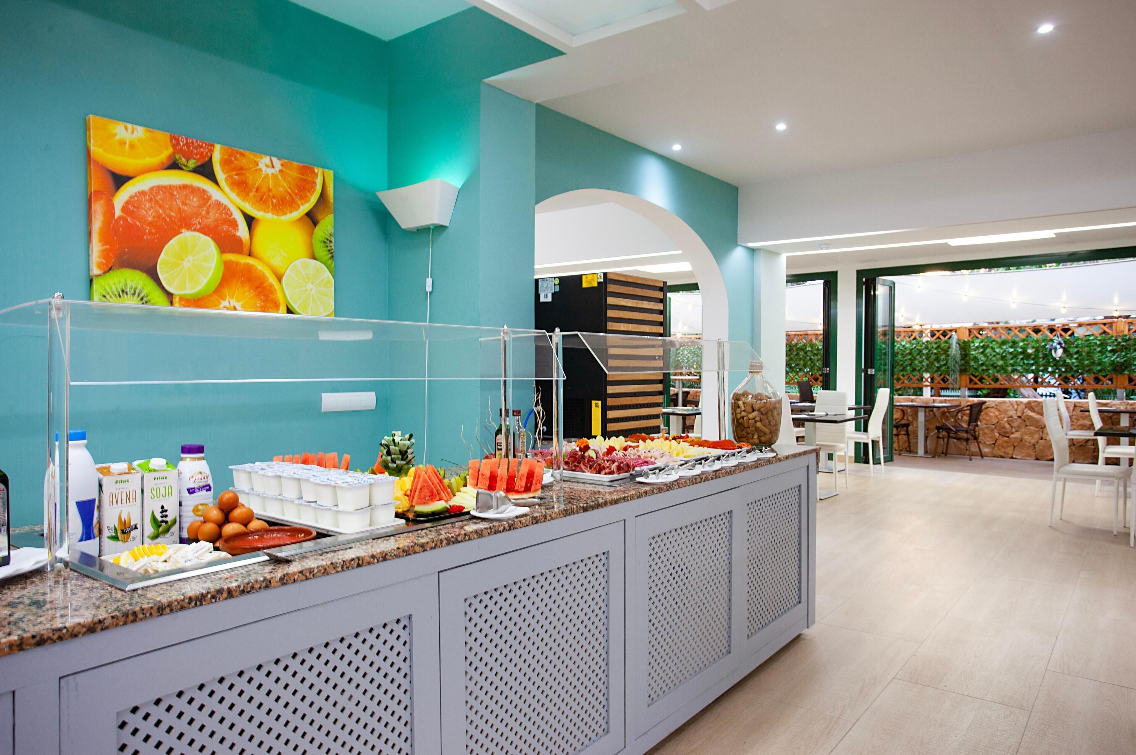 Een buffetgedeelte met diverse soorten fruit en drankjes.
