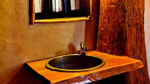 A rustic bathroom with a wooden sink and a mirror mounted on a tree trunk. - Eco Hostel - Tribo da Praia (Peniche)