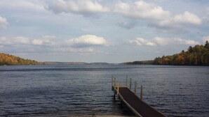 A wooden dock extending into a calm lake with a forested shoreline. - Bear Paw Inn (Michigamme)