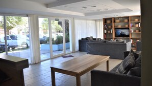 Una sala de estar moderna con un sofá, una mesa de centro de madera y un televisor sobre un mueble de madera.