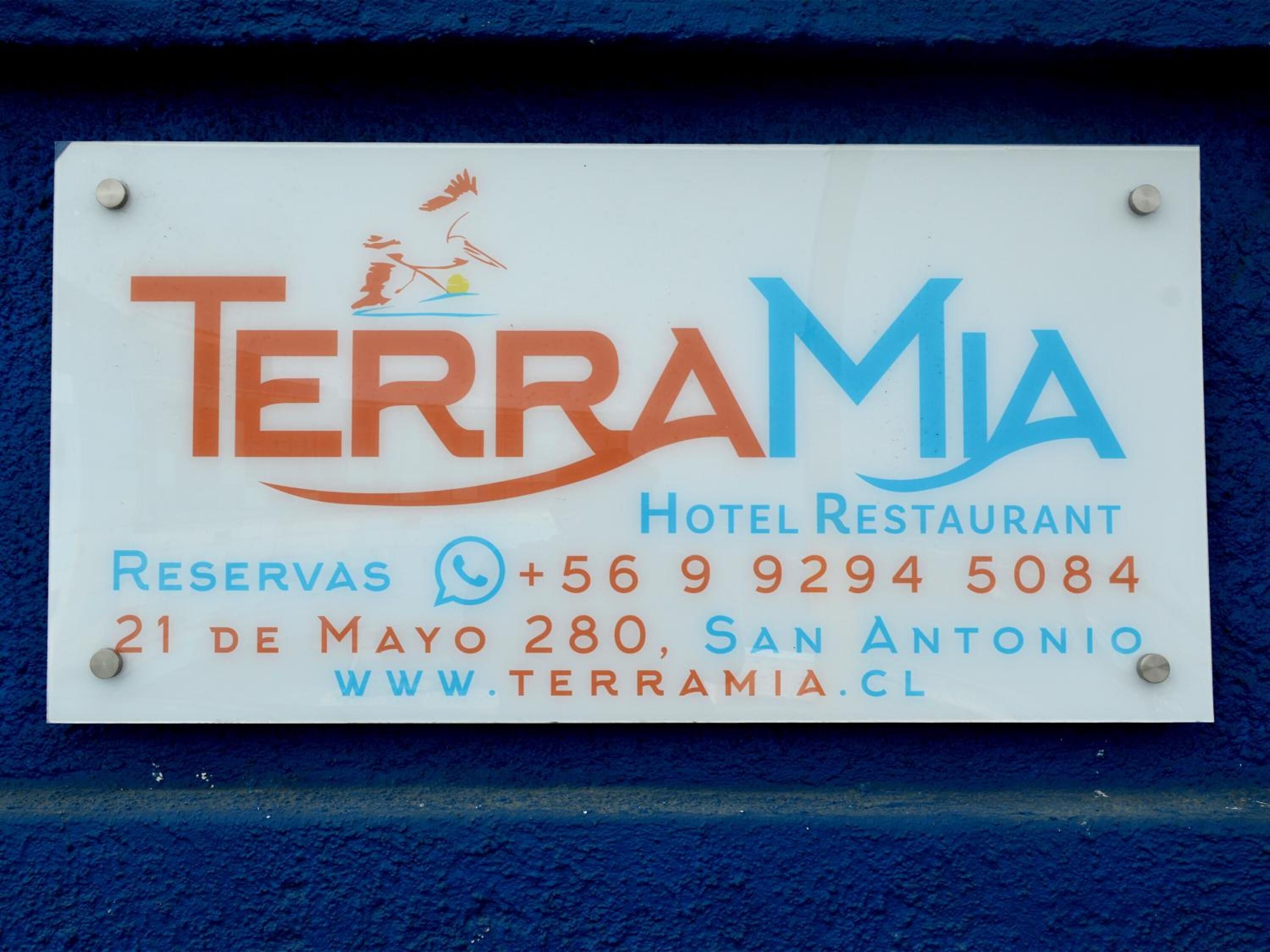 A sign for TerraMia Hotel Restaurant with contact information and address.