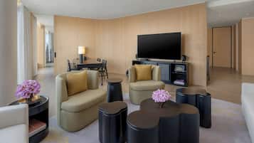 Een moderne woonkamer met een flatscreen televisie, twee banken, een salontafel en een bijzettafeltje met een bloevas.