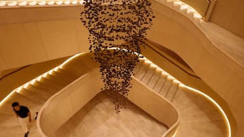 Una escalera de caracol con un diseño único, que presenta un hueco central y una persona bajando.