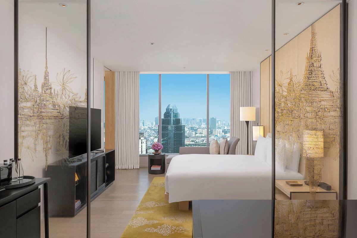 Une chambre d’hôtel moderne avec un grand lit, une télévision et une vue sur la ville.