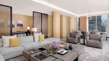 Un hotel moderno con sofá, sillones, una mesa de centro y vistas a la ciudad.