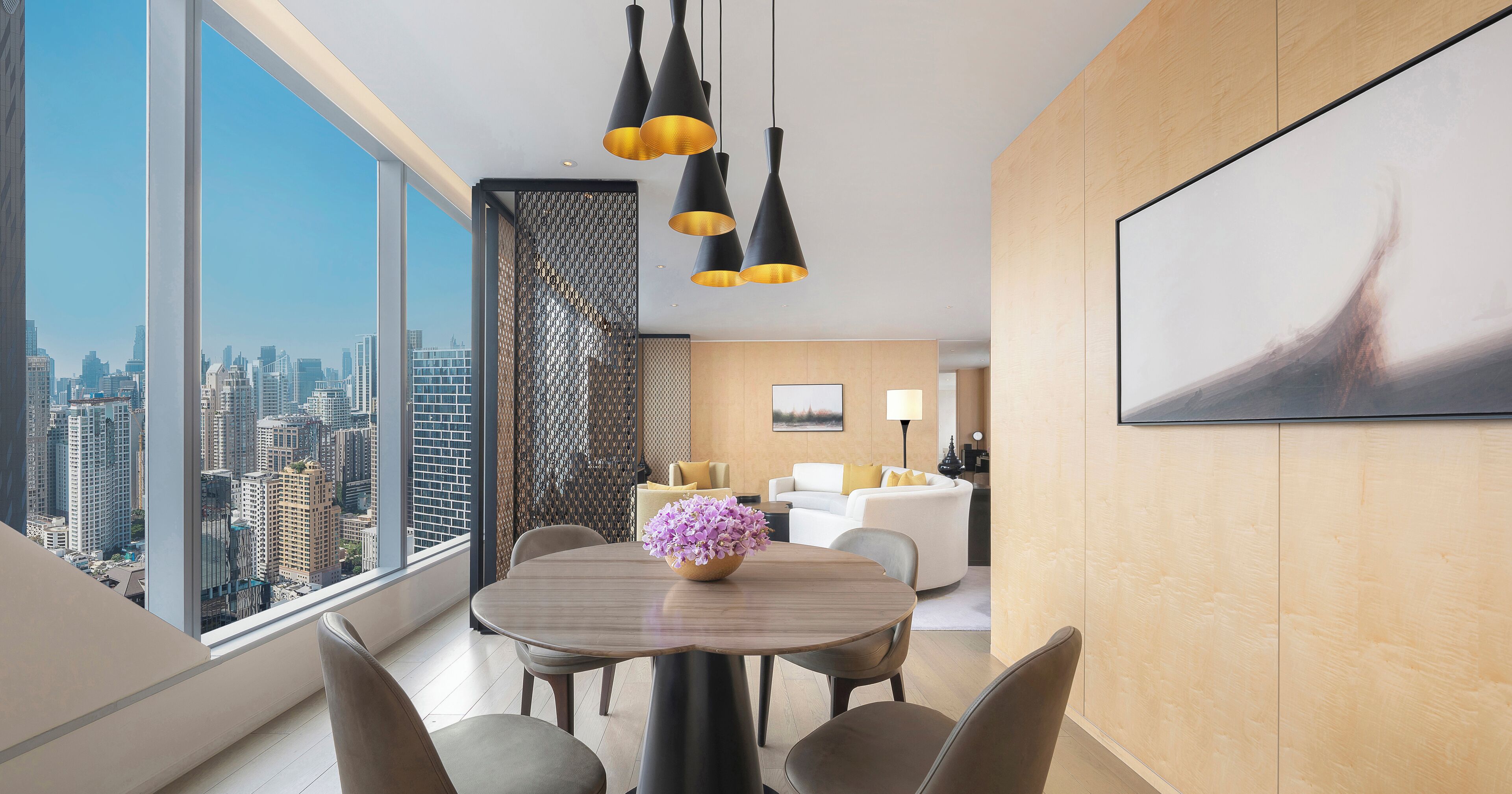 A modern dining area with a city view, a round table, and contemporary lighting.