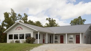 A two-story building with a sign reading "Cottonwood Inn." It has a gravel driveway, a covered front porch, and a metal roof. - Cottonwood Inn (Salem)