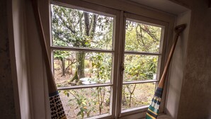 Janela com vista para um jardim e uma colher de pau apoiada na moldura.