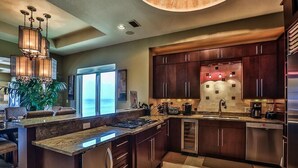 A modern kitchen with dark wood cabinets, stainless steel appliances, and a central island.