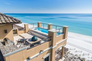 A beachfront property with a rooftop pool, outdoor seating, and a view of the ocean. - Ocean Paradise 4 Bedroom Holiday Home by Five Star Properties (Destin)