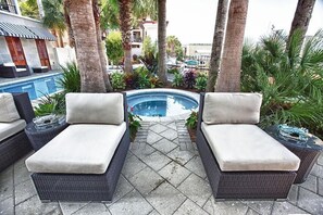 A poolside lounge area with two cushioned chairs and a small pool. - OLYMPIA CORAL SUITE 3 Bedroom Holiday Home by Five Star Properties (Destin)