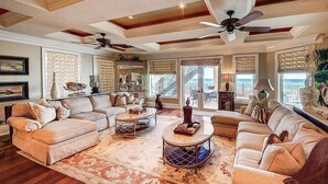 A spacious living room with a large sectional sofa, two coffee tables, and a ceiling fan. - Palazzo del Mar 11 Bedroom Holiday Home by Five Star Properties (Destin)