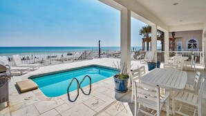A poolside area with a view of the sea, outdoor seating, and a covered patio. - Redefining Beach Time 7 Bedroom Holiday Home by Five Star Properties (Destin)