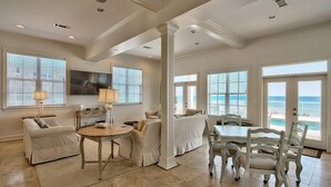 A spacious living room with a dining area, large windows, and a view of the ocean. - Redefining Beach Time 7 Bedroom Holiday Home by Five Star Properties (Destin)