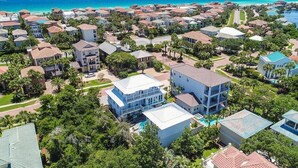 A coastal residential area with houses, a swimming pool, and a clear view of the ocean.