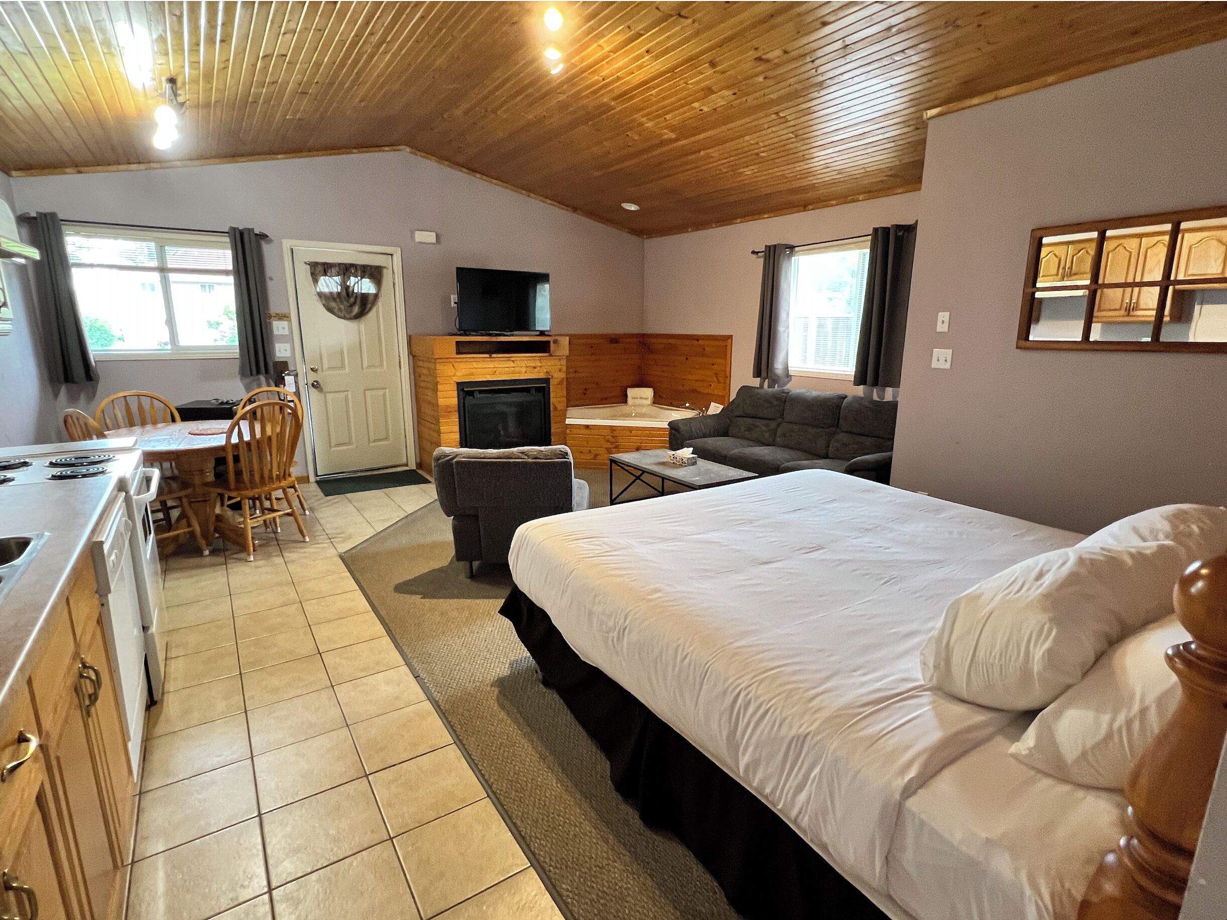 Una habitación acogedora con cama, sofá, comedor y chimenea.
