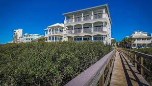 A multi-story beachfront hotel with balconies and a wooden boardwalk leading to the entrance. - SEAVIEW I UNIT 300 4 Bedroom Holiday Home by Five Star Properties (Santa Rosa Beach)