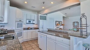A kitchen with white cabinets, granite countertops, and a dishwasher. - SEAVIEW I UNIT 300 4 Bedroom Holiday Home by Five Star Properties (Santa Rosa Beach)