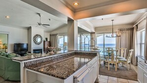 A spacious living area with a large island, a television, and a balcony with a view. - SEAVIEW I UNIT 300 4 Bedroom Holiday Home by Five Star Properties (Santa Rosa Beach)