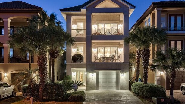 A multi-story residential building with a central entrance, balconies, and a driveway with parked cars. - Serenity 4 Bedroom Holiday Home by Five Star Properties (Destin)