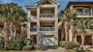 A multi-story residential building with a central garage, balconies, and palm trees. - Serenity 4 Bedroom Holiday Home by Five Star Properties (Destin)