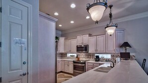A kitchen with light-colored cabinets, stainless steel appliances, a large island, and pendant lighting. - Serenity 4 Bedroom Holiday Home by Five Star Properties (Destin)