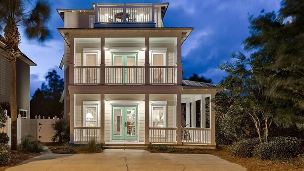 A two-story house with a balcony on the upper level, a front door, and a visible garage.