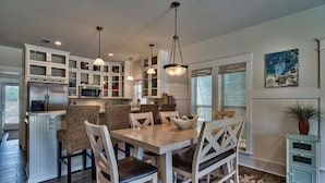 A spacious kitchen with white cabinetry, a central island, and pendant lighting.
