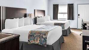 A hotel room with two beds, a desk, and a window with curtains. - SureStay Studio by Best Western Hardisty (Hardisty)
