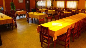 Un restaurante con varias mesas y sillas, dispuesto en un espacio amplio.