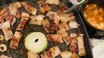A grill with various meats and vegetables being cooked.