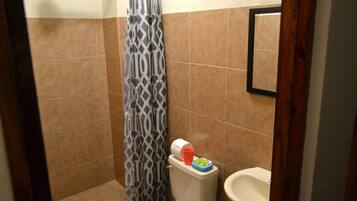 A small bathroom with a toilet, bidet, and shower curtain.