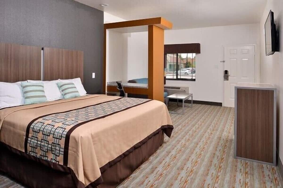 A hotel room with a bed, a desk, and a chair.