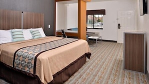 Una habitación de hotel con una cama, un escritorio y una silla.