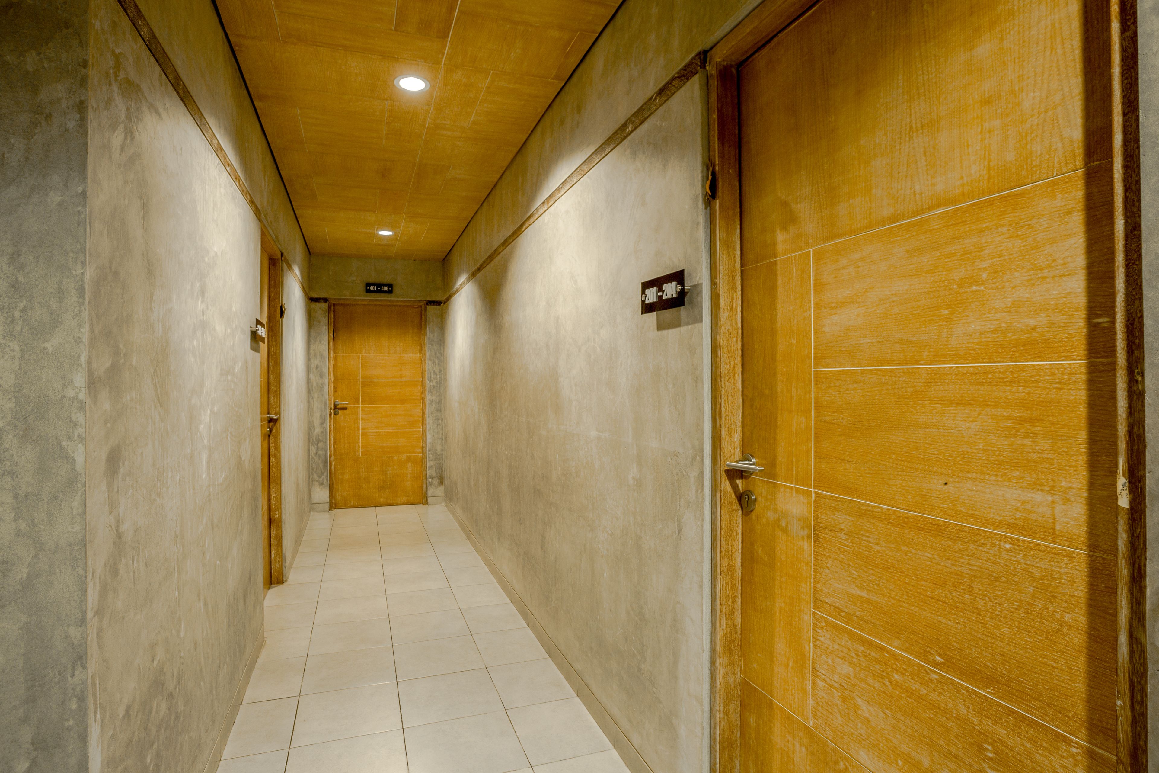 A hallway with wooden doors, tiled flooring, and a ceiling with recessed lighting.