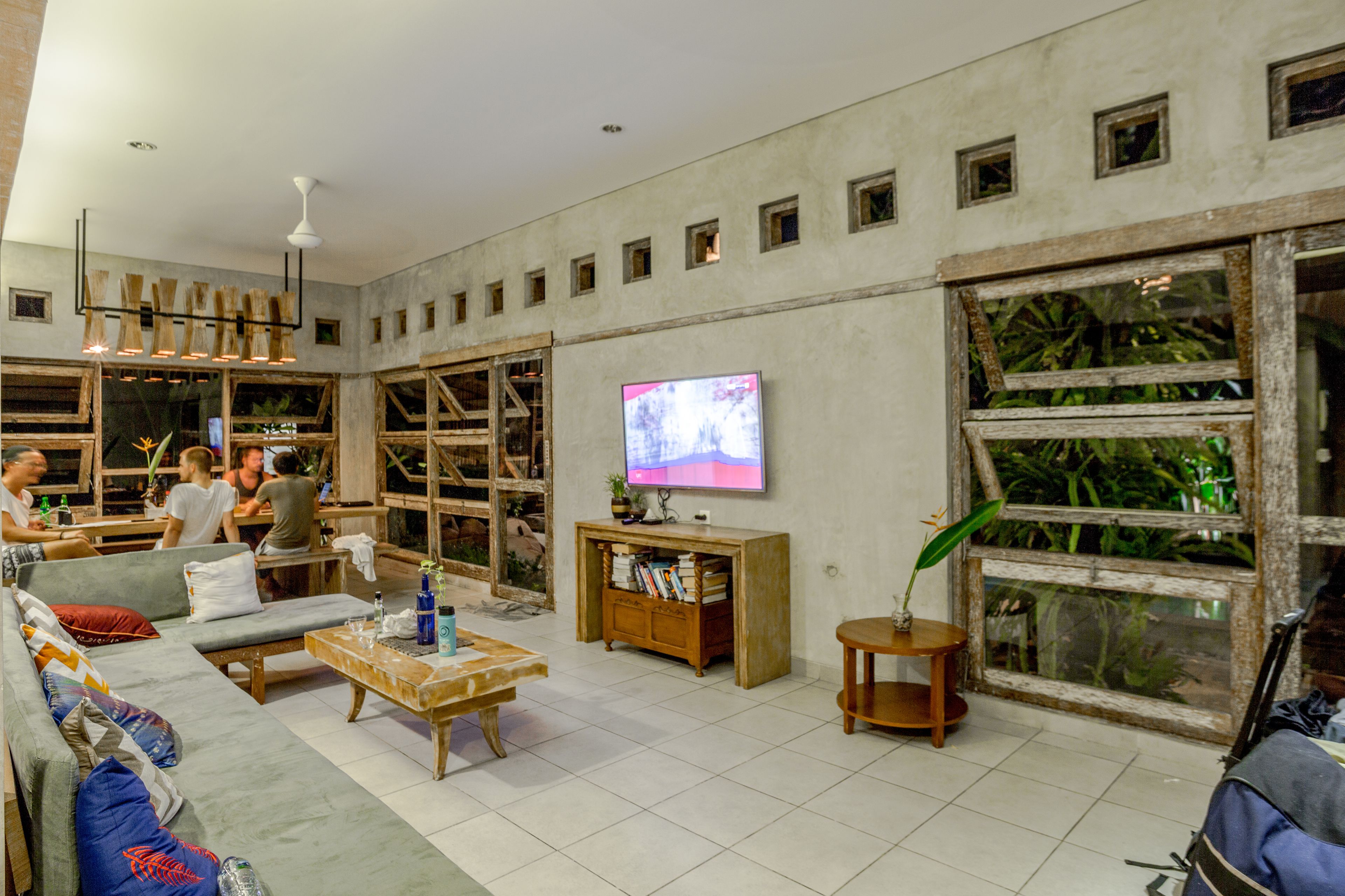 A spacious living area with a sofa, coffee table, and a television mounted on the wall.