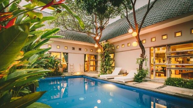 Piscina com espreguiçadeiras e área de restaurante.