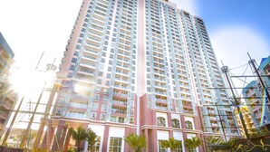 A high-rise hotel with multiple balconies, a swimming pool, and a ship-themed water feature. - Grande Caribbean Hotel Resort Pattaya (Pattaya)